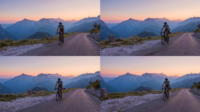 运动活跃的人公路骑自行车在一个美丽的阳光明媚的早晨，在黎明的背景下分层的山