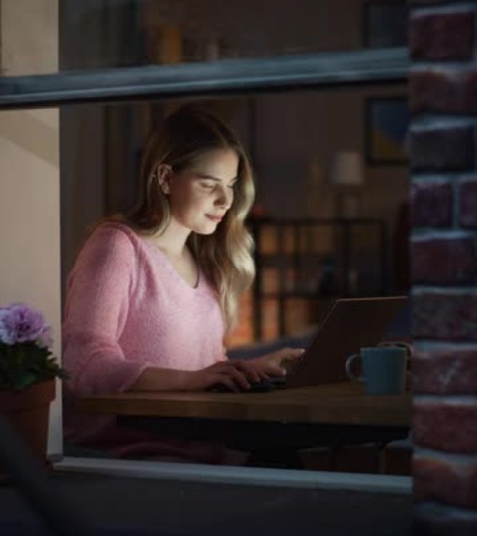 垂直镜头: 美丽的白人女人晚上在家用笔记本电脑工作。年轻的女性媒体关系经理制定品牌创新战略并在线与同