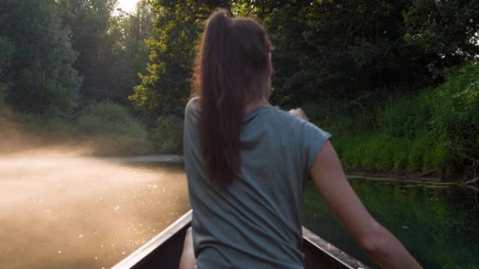 日落时乘独木舟探索雄伟的迷雾河的女人