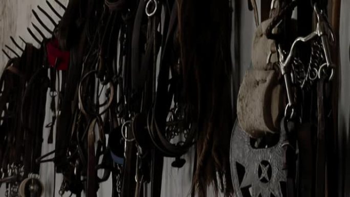 在阿根廷，传统的高乔骑马装备用于骑马悬挂在马Stable内的墙壁上。特写。