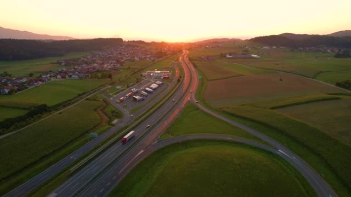 空中: 沿着繁忙的高速公路飞向美丽的金色日落。