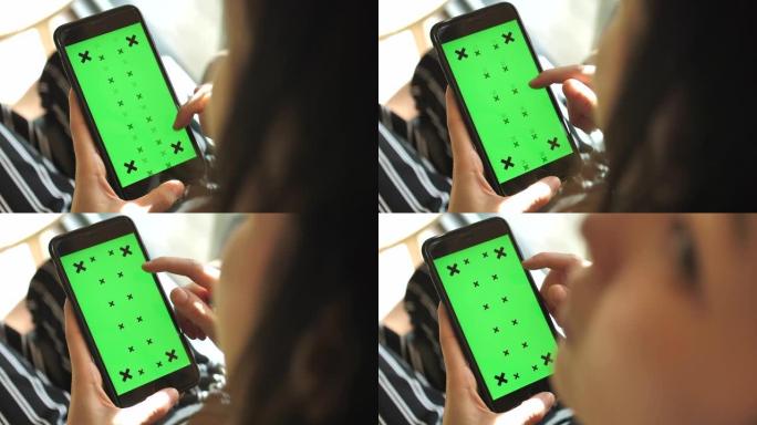 使用带有绿屏设备屏幕的手机的特写年轻女子