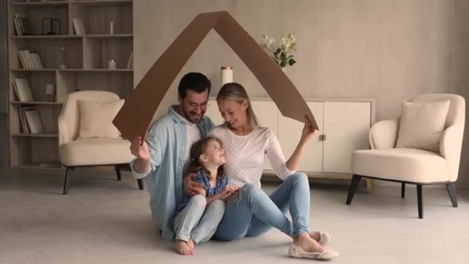 快乐的家庭，女儿坐在纸箱屋顶符号下