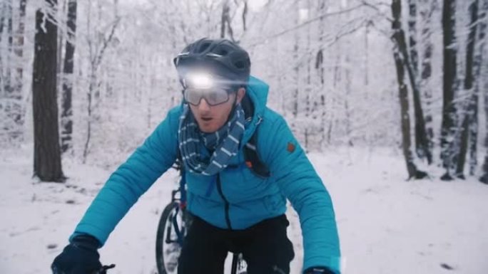 在下雪的冬季小径上与前灯骑行ebikes的情侣