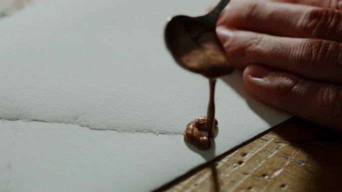 工匠造纸大师的宏正在车间密封高质量的手工纸。手工制作的概念，高品质，工匠，意大利制造，传统