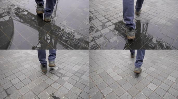 穿着牛仔裤和靴子的男人在湿瓷砖地板上行走的SLO MO后视图。