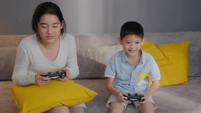 亚洲兄弟少女在家里和哥哥玩游戏机时竞争