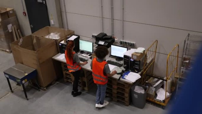 两个同事在仓库中使用计算机