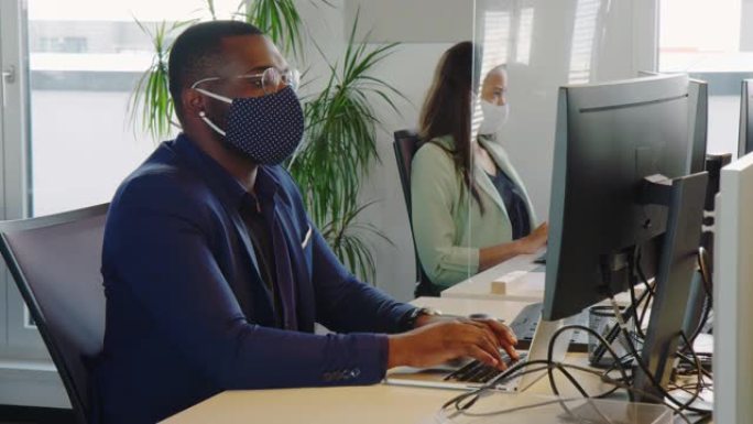 在办公室工作的戴着口罩的商务人士