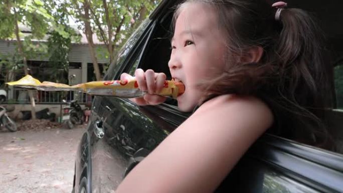 亚洲小女孩在车里吃零食