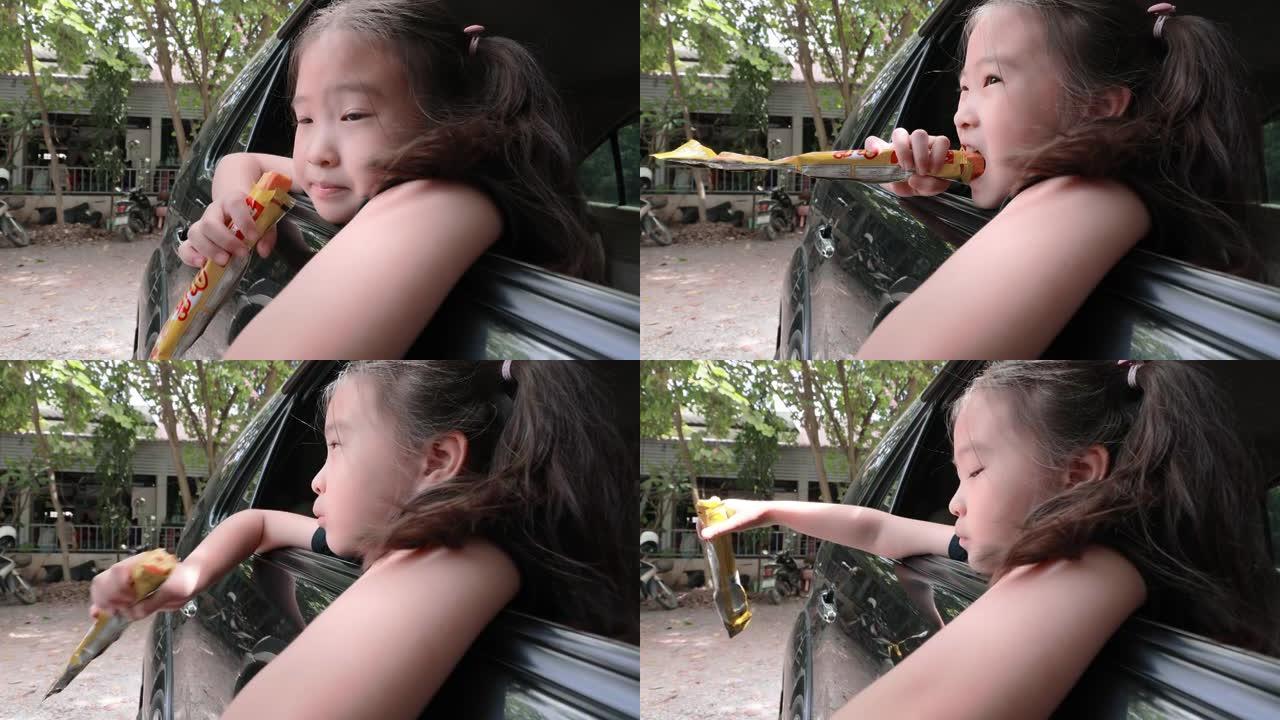 亚洲小女孩在车里吃零食