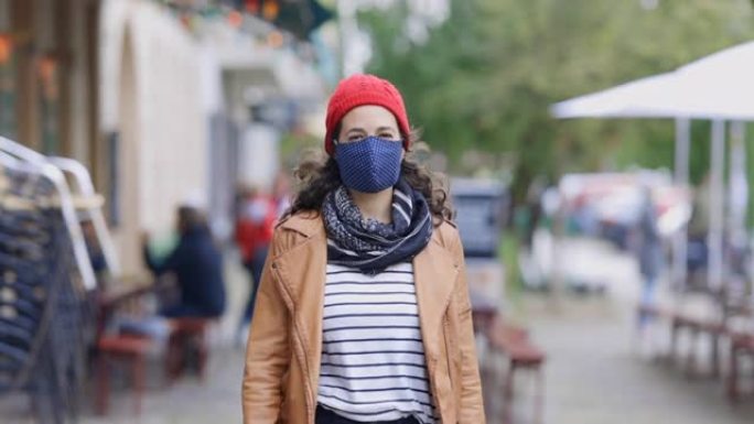 城市人行道上戴着面具的女性