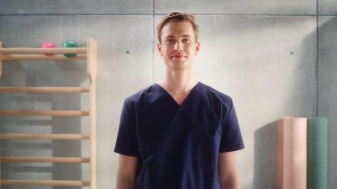 一位英俊的专业男护士站在镜头前摆姿势，在医疗康复中心微笑的肖像。医院理疗助理。年轻的执业医生。