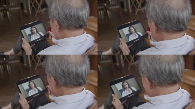 年迈的爷爷拿着一瓶药咨询医生，用平板电脑作为视频通话，以缩小他们之间的距离，减少传播感染的机会