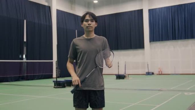 一个亚洲残疾人手持羽毛球拍的自信肖像。