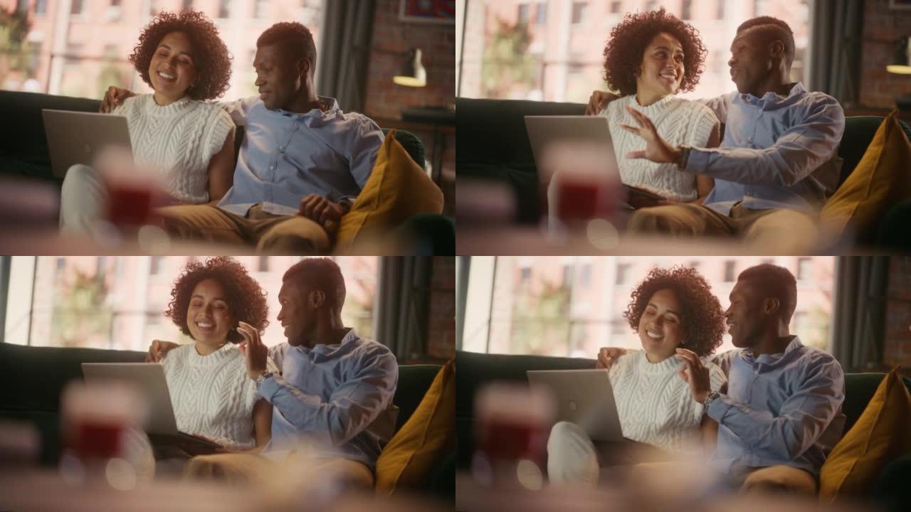一起的空闲时间。黑人夫妇在家里沙发上放松的半身肖像，一边看电脑。快乐的男朋友和女朋友用笔记本电脑谈笑