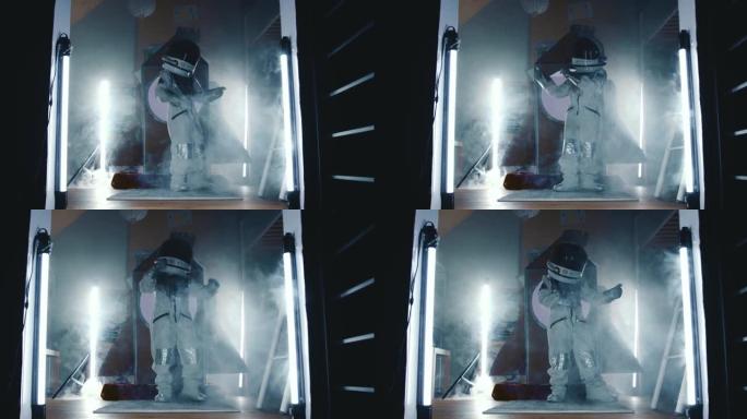 电影放大了快乐的太空人儿童在黑暗的房间里穿着宇航员服跳舞的灯光，在他的火箭船上冒烟。