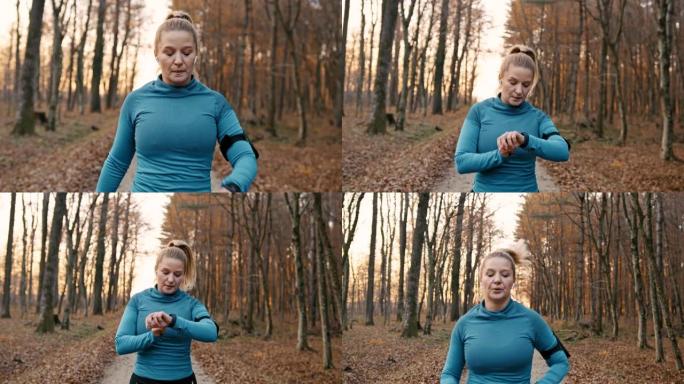 SLO MO女人在开始在森林里慢跑之前设置了健身追踪器