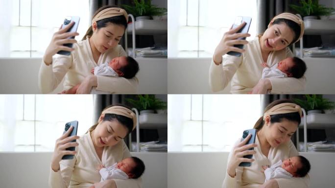 特写美女妈妈抱着可爱的小新生儿在手机上做视频通话。技术