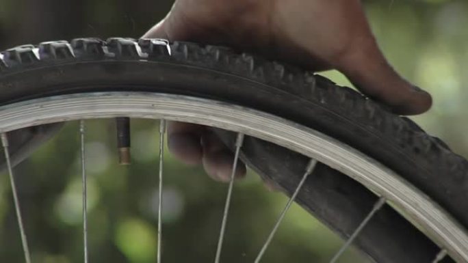 修理穿孔，男人在室外修补自行车内胎。特写。