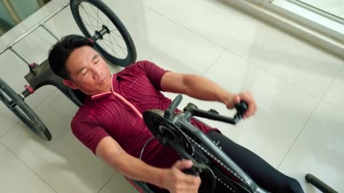 适应性运动员在他的赛车轮椅上训练。