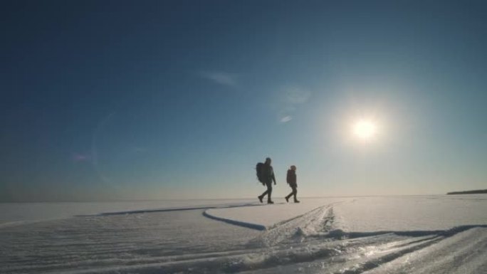 两个旅行者穿过雪原。慢动作