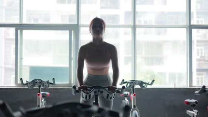 妇女在健身房骑自行车锻炼