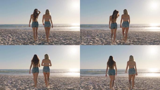 女孩朋友穿着牛仔短裤在海滩上散步，享受假期温暖的夏日