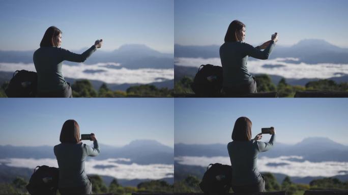 女旅行者在山上的日出时间拍张照片
