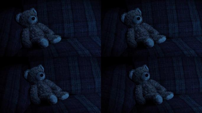 在黑暗中传递沙发上的泰迪熊
