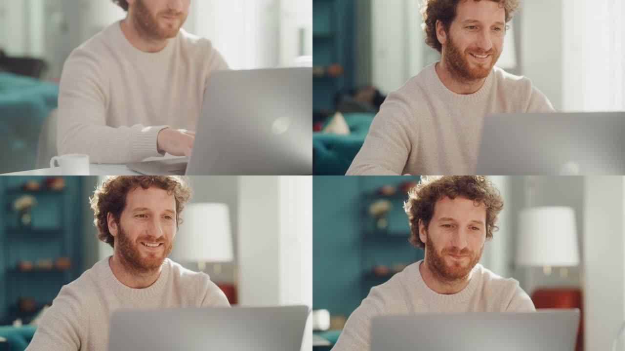 英俊的成年男子肖像，姜黄色卷发，使用笔记本电脑，坐在公寓的客厅。快乐的人在家工作，网上购物，看视频或