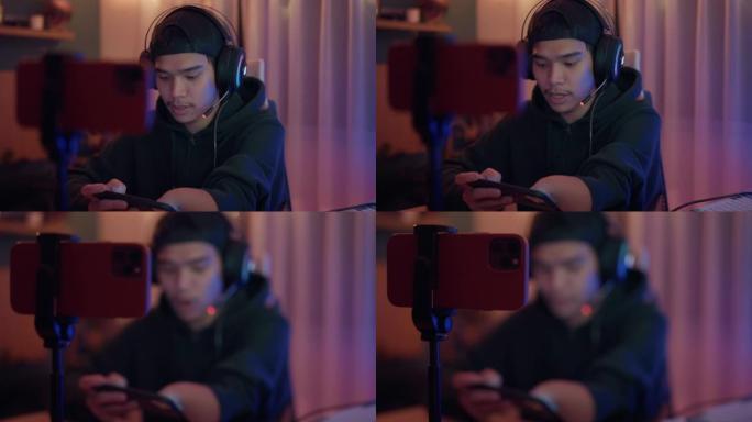 残疾的亚洲男性esport玩家在霓虹灯的房间里用智能手机玩激动人心的游戏。