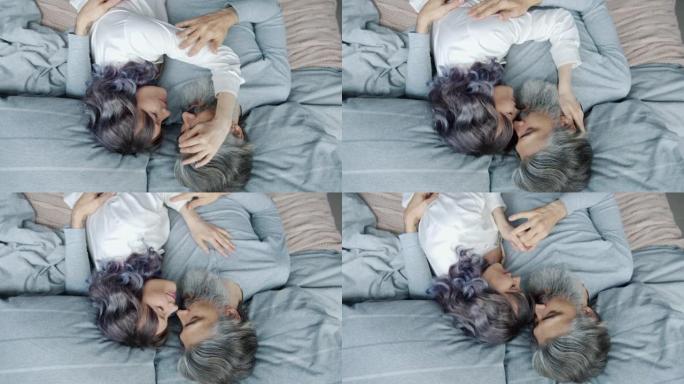 幸福夫妻躺在床上拥抱互相爱抚表达爱的高角度视图
