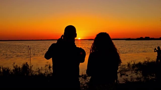 剪影夫妇在海洋地平线上拍摄日出