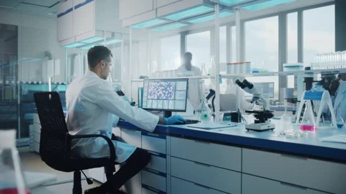 医学实验室与不同的多种族生物技术科学家团队开发药物，微生物学家在计算机上工作，显示基因编辑界面的显示