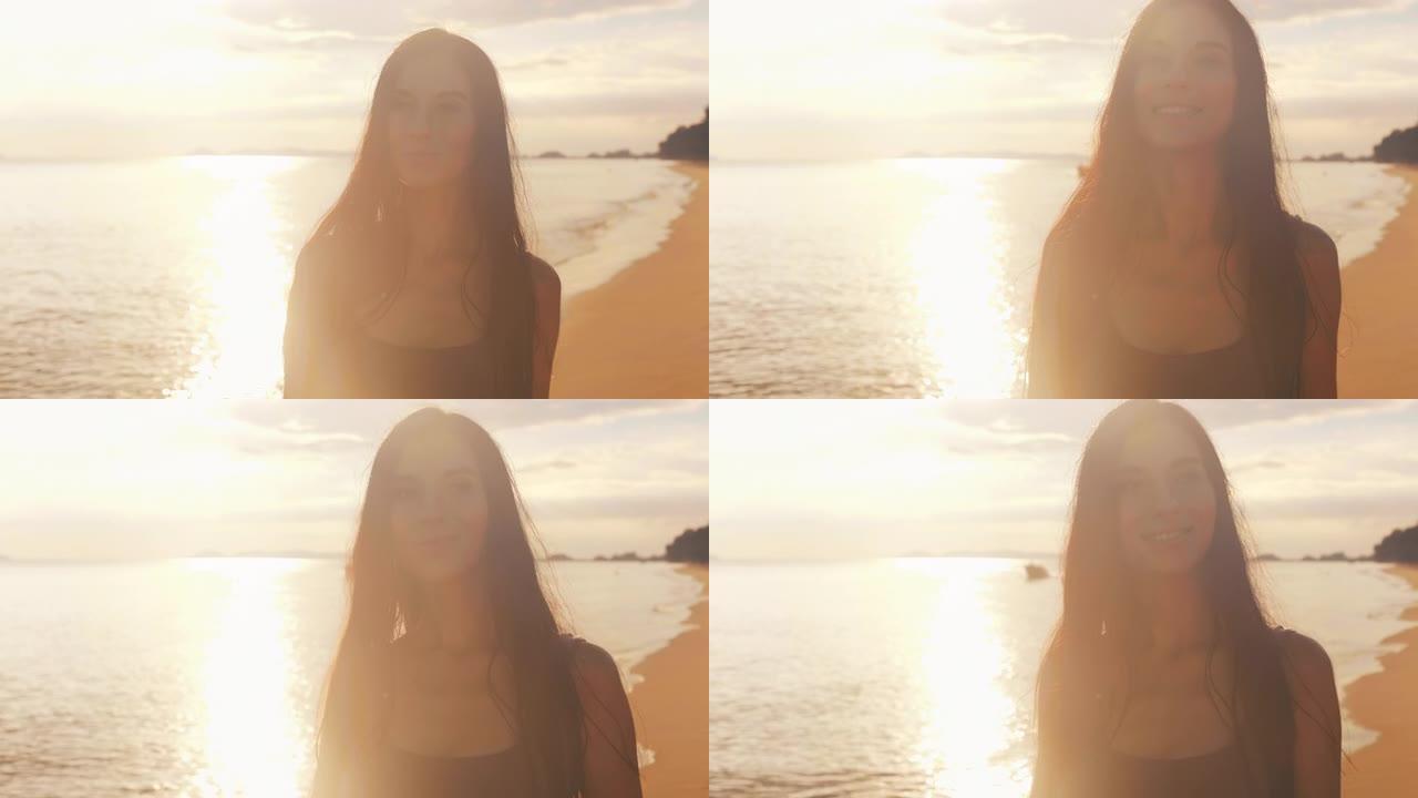 日落时沿着海滩散步的年轻女人