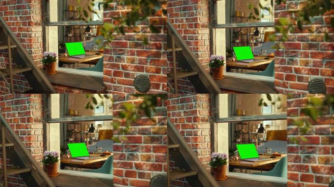 带绿屏模拟显示器的笔记本电脑站在时尚客厅的桌子上。从窗外可以看到布鲁克林风格的褐砂石多层建筑。在家工
