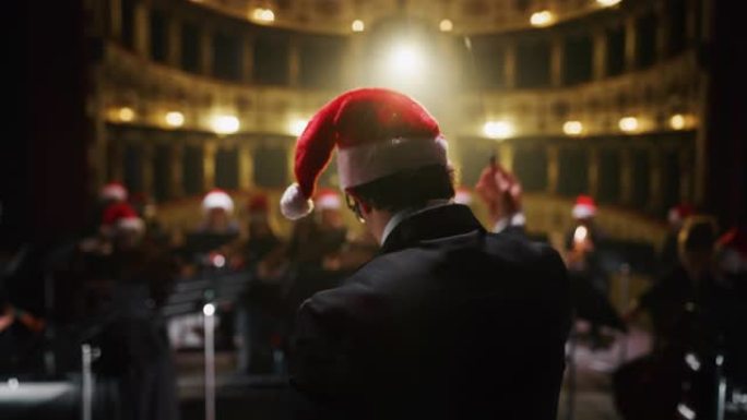 交响乐团的电影镜头，表演者都戴着圣诞老人的帽子，在圣诞节期间在经典剧院和窗帘舞台上演奏小提琴，大提琴