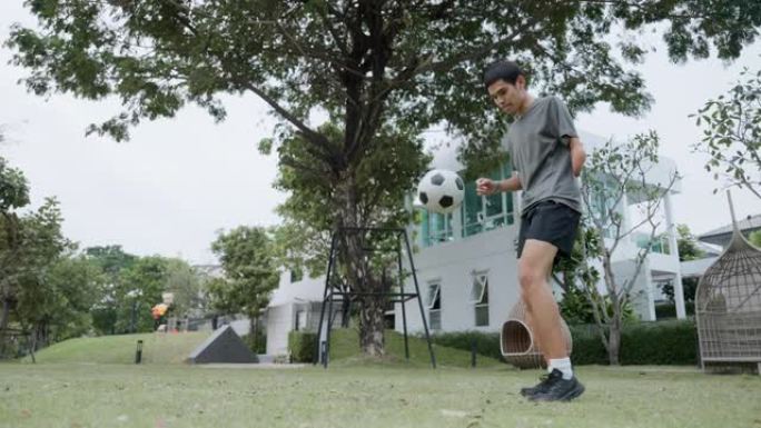 亚洲手臂残疾男子在场上练习足球技能。