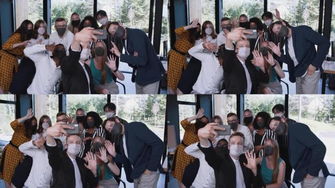 一群快乐的年轻多民族商人微笑着在现代办公室一起摆姿势拍摄智能手机自拍照片。
