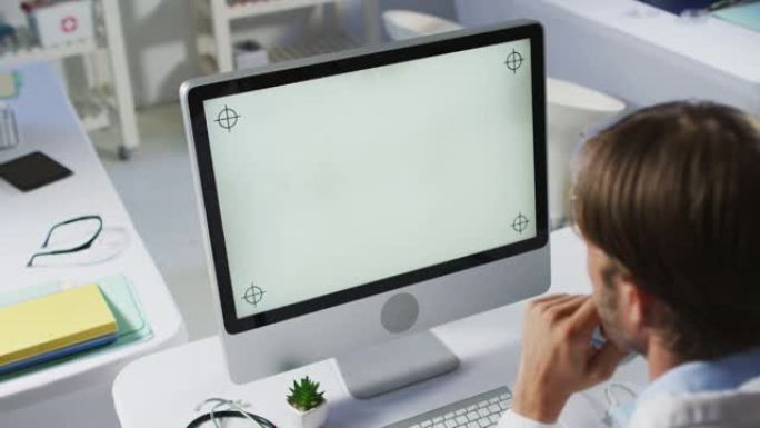 使用台式计算机进行视频通话咨询的白人男性医生