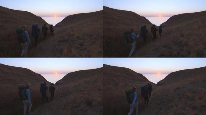 四人在海景背景上爬山。慢动作