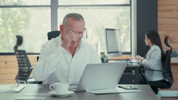 一名商人在办公室与同事一起使用笔记本电脑的4k录像