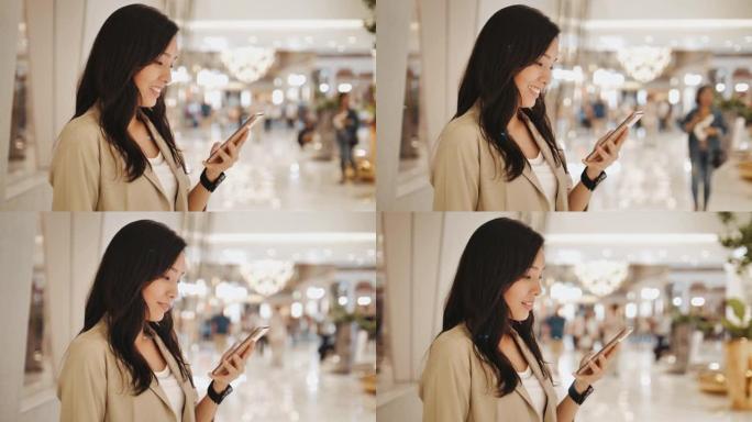 在购物中心使用智能手机的亚洲女性
