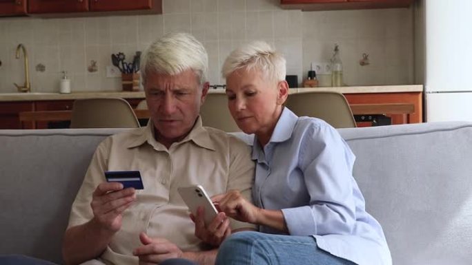 成熟的夫妇喜欢使用智能手机和借记卡在线购物