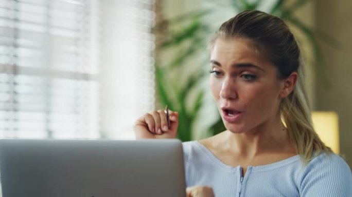年轻女子的真实镜头正在用笔记本电脑与同事进行视频电话会议，同时在家里的客厅里工作。概念: 智能工作，