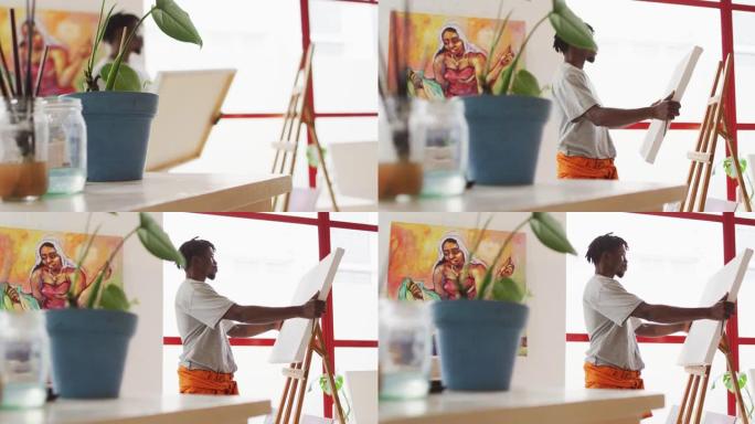 非裔美国男性画家在艺术家工作室将画布放在画架上
