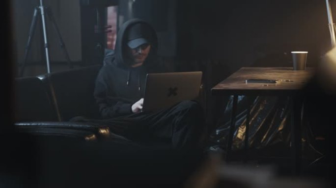 一个程序员躺在沙发上，靠在背包上，输入计算机代码