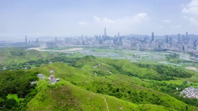 香港与中国深圳天际线之间的带有鱼塘的乡村绿地景观