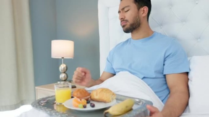 卧室，早餐和男人在酒店用餐，享受新鲜出炉的羊角面包，松饼和香蕉水果。食物，款待和饥饿的人喝橙汁并在假